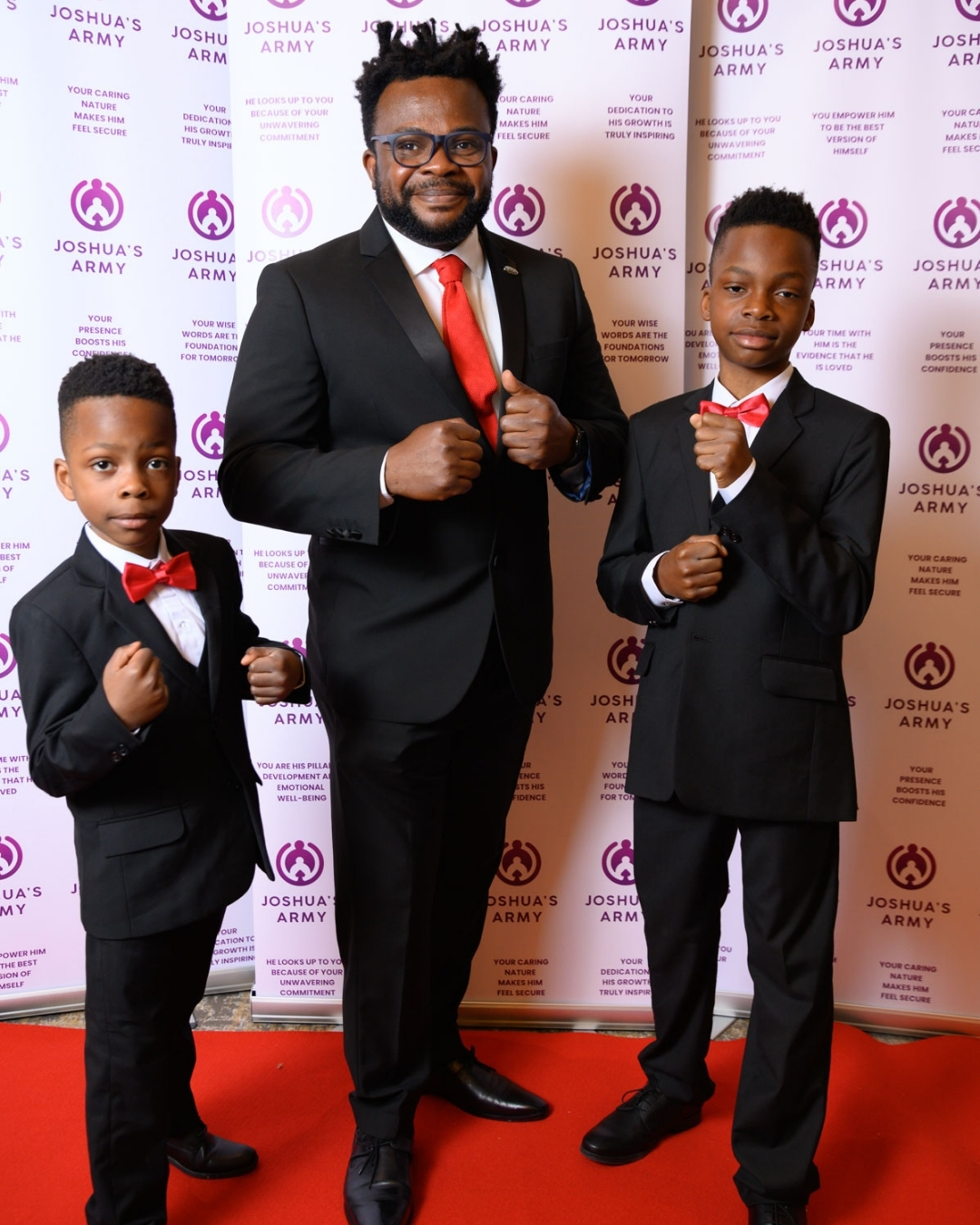 Father and young sons in sharp suits and bowties posing